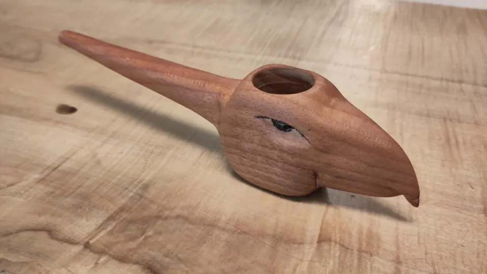 Geschnitzter Vogel aus Holz auf einer Tischplatte